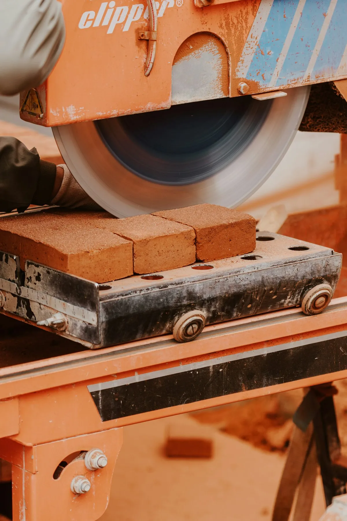 A masonry saw cutting a brick on a site bench