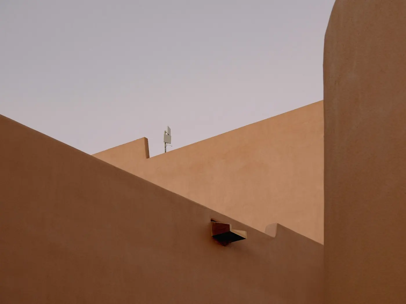 Modern earthen civic building with deep shaded openings