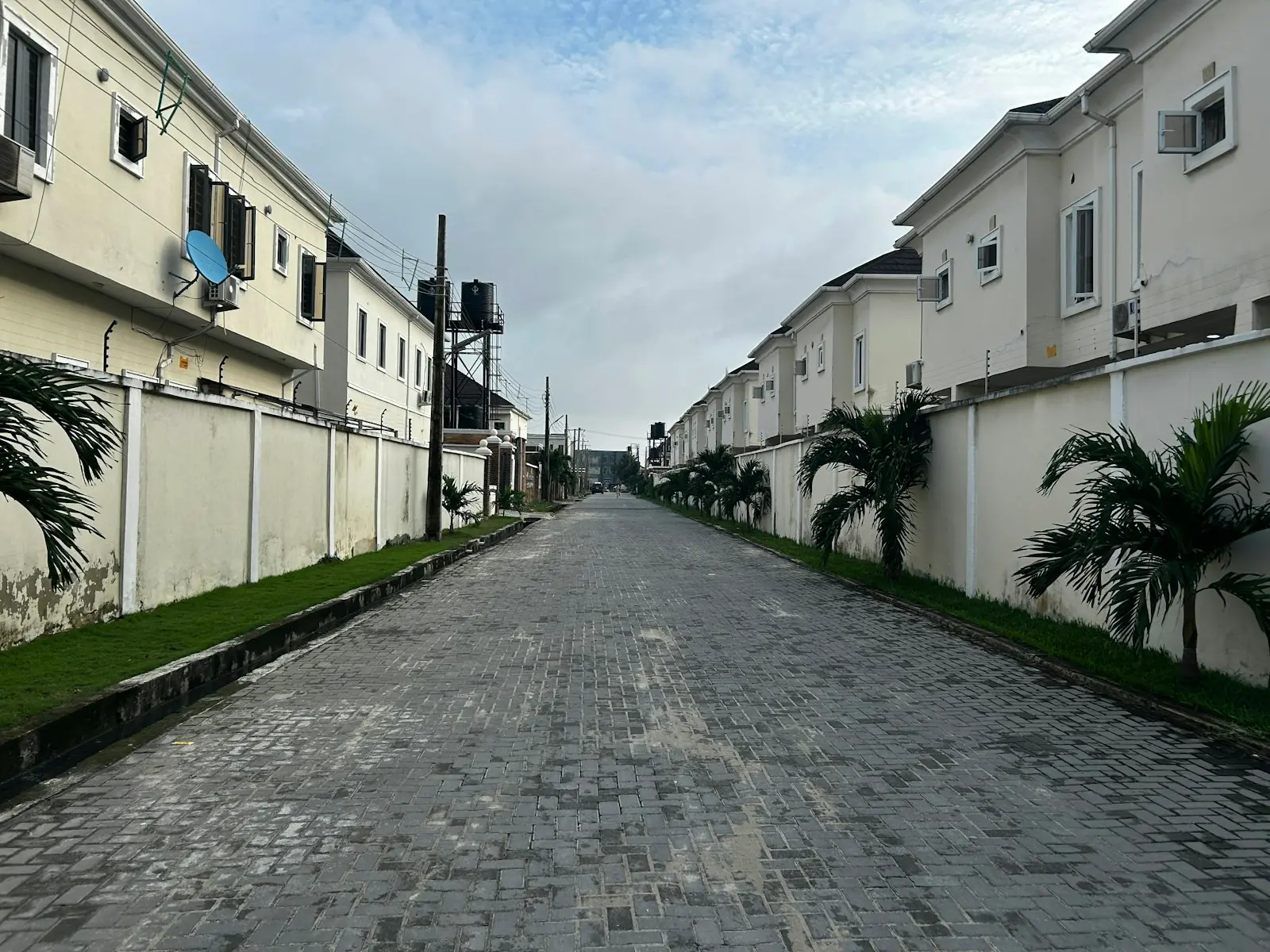 A residential street with a paved surface running between low-rise houses